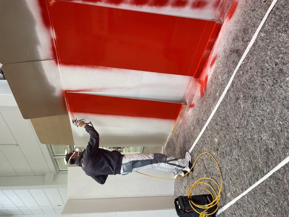 Handwerker bei der Airless-Spritzlackierung eines Bauteils